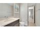 Bright bathroom with light tile, a modern vanity, and a view down the hallway at 7921 Jacks Club Dr, Kissimmee, FL 34747