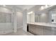 Bathroom with double sink vanity, large mirror, and glass-enclosed shower with mosaic tile at 7921 Jacks Club Dr, Kissimmee, FL 34747