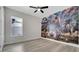 Spacious bedroom featuring wood-look flooring, ceiling fan and a Jurassic World themed wall at 7921 Jacks Club Dr, Kissimmee, FL 34747