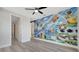 Spacious room with colorful wall art, grey flooring and a hallway leading to other rooms at 7921 Jacks Club Dr, Kissimmee, FL 34747