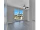 Bright bedroom with light grey wood floors, ceiling fan and sliding glass doors to a balcony at 7921 Jacks Club Dr, Kissimmee, FL 34747