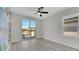 Bright bedroom with light grey wood floors, ceiling fan and sliding glass doors to a balcony at 7921 Jacks Club Dr, Kissimmee, FL 34747