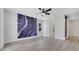 Spacious bedroom featuring modern light fixture, beautiful accent wall and wood-style floors at 7921 Jacks Club Dr, Kissimmee, FL 34747