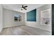 Bright bedroom with a ceiling fan, large window and elegant wood-look flooring at 7921 Jacks Club Dr, Kissimmee, FL 34747
