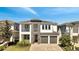 Modern two-story home with a stylish stone accent, a covered balcony, and a two-car garage at 7921 Jacks Club Dr, Kissimmee, FL 34747