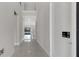 Long hallway with tile floors and view to pool and natural light through rear windows at 7921 Jacks Club Dr, Kissimmee, FL 34747