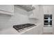 A beautifully appointed kitchen featuring a Samsung cooktop, white subway tile backsplash, and modern white cabinetry at 7921 Jacks Club Dr, Kissimmee, FL 34747