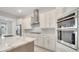 A sleek kitchen featuring a large island, stainless steel appliances, and modern white cabinetry at 7921 Jacks Club Dr, Kissimmee, FL 34747