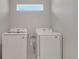 Clean and bright laundry room features side-by-side washer and dryer with window above at 7921 Jacks Club Dr, Kissimmee, FL 34747