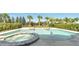 Resort-style pool with a built-in spa and fountains, surrounded by lush landscaping and palm trees at 7921 Jacks Club Dr, Kissimmee, FL 34747