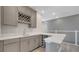 A wet bar with gray cabinets, quartz countertops, a wine rack, and stainless steel hardware at 7921 Jacks Club Dr, Kissimmee, FL 34747