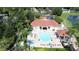 Aerial view of a community pool, hot tub, and clubhouse surrounded by lush landscaping and well-maintained grounds at 8462 Secret Key Cv, Kissimmee, FL 34747
