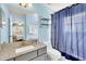 Bathroom featuring blue walls, granite countertop and shower with blue curtain at 8462 Secret Key Cv, Kissimmee, FL 34747