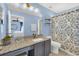 Well-lit bathroom with granite countertops and a decorative shower curtain at 8462 Secret Key Cv, Kissimmee, FL 34747
