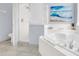 A bright bathroom featuring a shower, soaking tub, blue abstract art, and tiled floors at 8462 Secret Key Cv, Kissimmee, FL 34747
