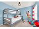 bedroom with grey bunk beds, blue walls and playful décor at 8462 Secret Key Cv, Kissimmee, FL 34747