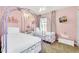 Charming pink bedroom featuring two beds with carriage frames and crown decor at 8462 Secret Key Cv, Kissimmee, FL 34747