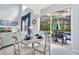 Dining area with white table, chairs, and chandelier, leading to an outdoor patio and pool area at 8462 Secret Key Cv, Kissimmee, FL 34747
