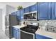 Well-equipped kitchen featuring blue cabinets, stainless steel appliances, and ample counter space at 8462 Secret Key Cv, Kissimmee, FL 34747