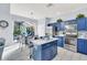 Modern kitchen featuring blue cabinetry, stainless steel appliances, and a view to a screened outdoor space at 8462 Secret Key Cv, Kissimmee, FL 34747