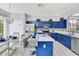 Well-equipped kitchen with stylish blue cabinetry and a view to the dining area at 8462 Secret Key Cv, Kissimmee, FL 34747
