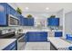 Beautiful blue cabinets and white counters highlight this well-appointed kitchen with stainless appliances at 8462 Secret Key Cv, Kissimmee, FL 34747
