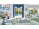 Bright living room with pool view through sliding glass doors and elegant blue accents at 8462 Secret Key Cv, Kissimmee, FL 34747