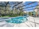 Screened-in pool and spa with sun loungers and tropical landscaping at 8462 Secret Key Cv, Kissimmee, FL 34747