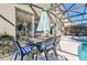 Poolside dining area with a table, chairs, and umbrella at 8462 Secret Key Cv, Kissimmee, FL 34747