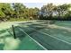 Well-maintained tennis court surrounded by trees, offering residents a great place for recreation at 8462 Secret Key Cv, Kissimmee, FL 34747