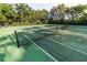 Well-maintained tennis court surrounded by trees, offering residents a great place for recreation at 8462 Secret Key Cv, Kissimmee, FL 34747
