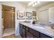 Bathroom with double sinks, granite countertop and modern vanity, and a glass enclosed shower at 8908 Adriatico Ln, Kissimmee, FL 34747