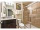 Cozy bathroom featuring granite countertop vanity, large framed mirror and a tiled walk-in shower at 8908 Adriatico Ln, Kissimmee, FL 34747