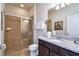 Well-lit bathroom featuring a tiled shower, granite countertop, and sleek vanity at 8908 Adriatico Ln, Kissimmee, FL 34747
