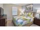 Bright bedroom with a large window, lamps on nightstands and a colorful quilt on the bed at 8908 Adriatico Ln, Kissimmee, FL 34747