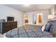 Comfortable bedroom with a large patterned bed, dark wood dresser, and a glimpse of the en-suite bathroom at 8908 Adriatico Ln, Kissimmee, FL 34747