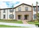 Charming townhome featuring a neutral palette, shutters, manicured lawn, and walkway at 8908 Adriatico Ln, Kissimmee, FL 34747