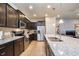 Modern kitchen features granite countertops, stainless steel appliances, and dark wood cabinets at 8908 Adriatico Ln, Kissimmee, FL 34747