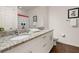 Well-lit bathroom with double sinks, granite countertops, and a vanity, offering a convenient and functional space at 8982 Shine Drive, Kissimmee, FL 34747