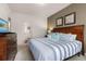 Comfortable bedroom featuring a king-sized bed, a dresser, and an en-suite bathroom for added privacy and convenience at 8982 Shine Drive, Kissimmee, FL 34747