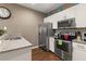 Modern kitchen featuring stainless steel appliances, granite countertops, and sleek white cabinetry at 8982 Shine Drive, Kissimmee, FL 34747