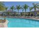 Refreshing community pool surrounded by lounge chairs and palm trees, perfect for relaxation at 8982 Shine Drive, Kissimmee, FL 34747
