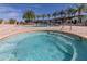 Inviting community pool and jacuzzi surrounded by palm trees and lounge chairs at 8982 Shine Drive, Kissimmee, FL 34747