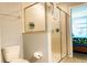 Bright bathroom featuring a glass shower with tile surround, toilet, and modern fixtures at 9156 Wedge Dr, Davenport, FL 33896