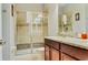Bathroom with glass door shower, granite countertops, and earth tone tile at 9156 Wedge Dr, Davenport, FL 33896