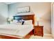 Comfortable bedroom with a decorative palm tree pillow and a hardwood nightstand at 9156 Wedge Dr, Davenport, FL 33896