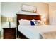 Comfortable bedroom with a decorative palm tree pillow and a hardwood nightstand at 9156 Wedge Dr, Davenport, FL 33896