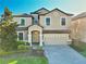 Charming two-story home featuring a tile roof, manicured landscaping, and a brick paver driveway at 9156 Wedge Dr, Davenport, FL 33896