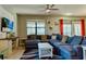 Spacious living room featuring a large sectional sofa, a ceiling fan, and backyard access at 9156 Wedge Dr, Davenport, FL 33896