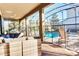 Covered patio with outdoor seating and a view of the sparkling pool, perfect for relaxation and entertainment at 9156 Wedge Dr, Davenport, FL 33896